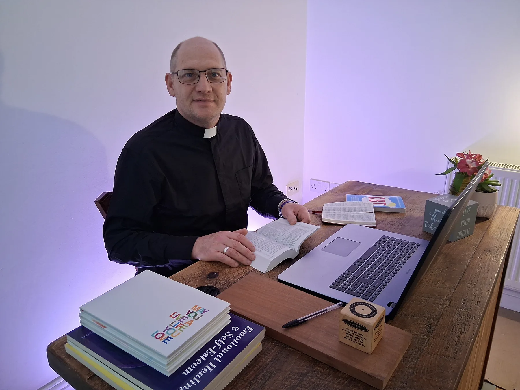 Rev'd Elton Moore at his desk with books and laptop